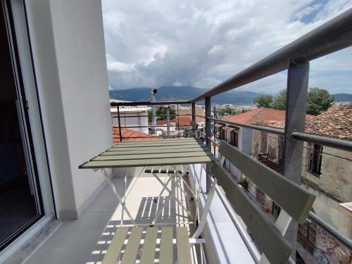 a balcony with a table and chairs on a building at Palaia premium flat in Volos