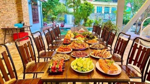 a long wooden table with plates of food on it at 1992 Tam Đảo - Venuestay in Tam Ðảo