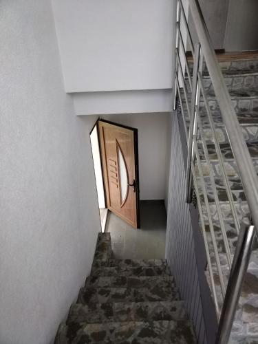 a stairway with a wooden door and a stair case at Nice view-Plitvice in Korenica