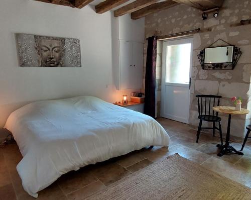 sypialnia z łóżkiem, stołem i telewizorem w obiekcie Le Clos des Roses w mieście Parçay-les-Pins