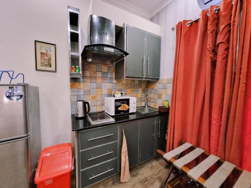 a small kitchen with a stove and a microwave at Hayyat Luxury Suites in Lahore