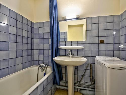 une salle de bain carrelée bleue avec un lavabo et une baignoire dans l'établissement Arcachon: T2 Accès Privé Plage, Balcon, Parking - FR-1-433-19, à Arcachon