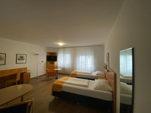 Cette chambre comprend 2 lits et une table. dans l'établissement Ariva Boardinghouse Platanenhof, à Mannheim