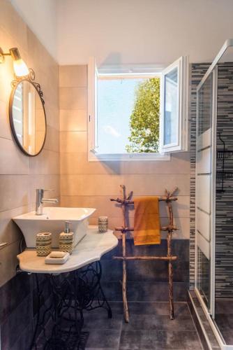 a bathroom with a sink and a mirror and a window at Yellow Bike House in Lefkimmi