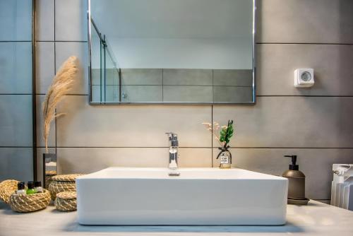 a bathroom with a white sink and a mirror at Aristotelis Apartment Lakithra-Alexandra in Lakithra