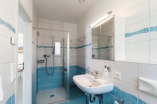 a blue and white bathroom with a sink and a shower at Casa Mummi by Quokka 360 - with garden 5 min from Ascona in Losone