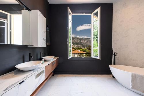 a bathroom with two sinks and a large window at MY CASA - Honore Sauvan - Villa Design Swimming Pool Sauna Sea View in Saint-Jean-Cap-Ferrat