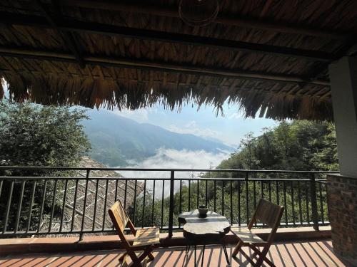a table and chairs on a deck with a view at Ta Xua Ecolodge in Bắc Yên