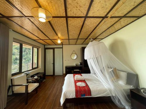 a bedroom with a bed with a mosquito net at Ta Xua Ecolodge in Bắc Yên