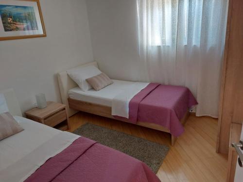 a small bedroom with two beds and a window at Kuća za odmor in Brzac