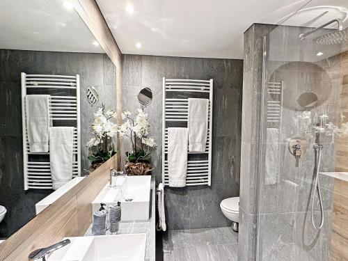 a bathroom with two sinks and a shower at 41m2 Alpenschick mit Ausblick - Pool - 2P - E405 in St. Moritz