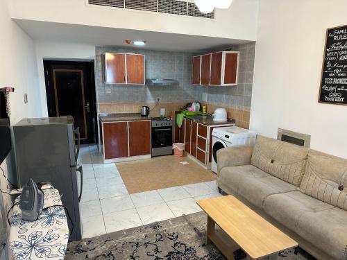 a living room with a couch and a kitchen at Apartment in Ajman,Studio flat in Ajman 