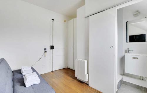 - un salon avec un canapé gris et un miroir dans l'établissement Amsterdam 12 - Charmant studio à Saint-Lazare, à Paris