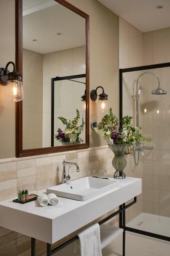 a bathroom with a sink and a mirror and a shower at Andrássy Kúria & Spa in Tarcal