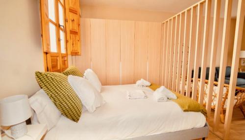 1 dormitorio con 1 cama con sábanas y almohadas blancas en El ALMA de Granada, en Granada