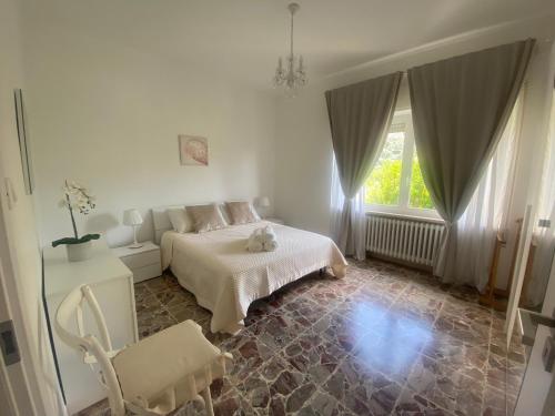 ein Schlafzimmer mit einem Bett, einem Stuhl und einem Fenster in der Unterkunft Casa Matilde & Aurora con giardino e posto auto privato in Sirolo
