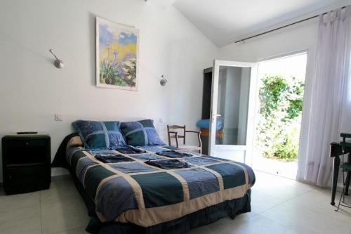a bedroom with a bed and a large window at LA VILLA DU CAP in Cap-Ferret