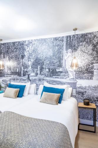 a bedroom with a large white bed with blue pillows at Hotel Presidente by Maxi Hoteles in Granada