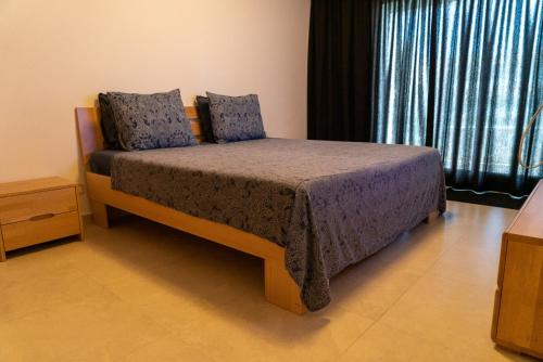 a bedroom with a bed with blue pillows on it at Intimate Apartment with a beautiful view in Tangier