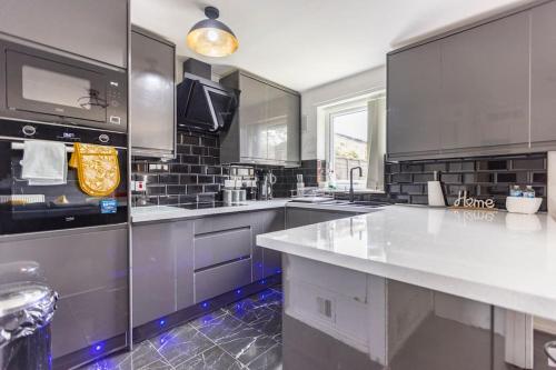 a large kitchen with stainless steel appliances and counters at Modernised 2 Bed House close to City Centre in Hunslet