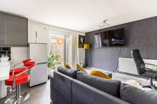 a living room with a couch and a kitchen at Modernised 2 Bed House close to City Centre in Hunslet