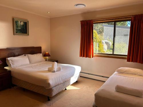 a bedroom with two beds and a window at Top Deck by Kristall Apartments in Jindabyne