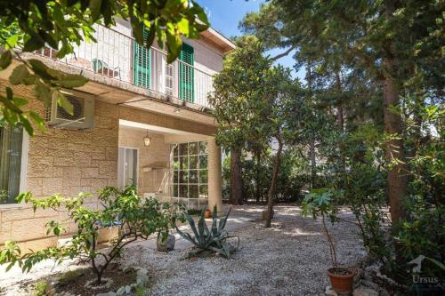 una casa con balcón y árboles frente a ella en Villa Linda, en Split