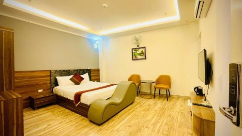 um quarto de hotel com uma cama, uma mesa e cadeiras em Win Villa Hotel & Apartment em Hanói