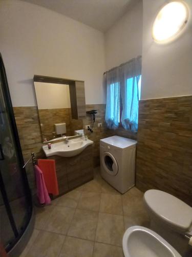 a bathroom with a sink and a toilet and a mirror at Domus Shardana in Gonnesa