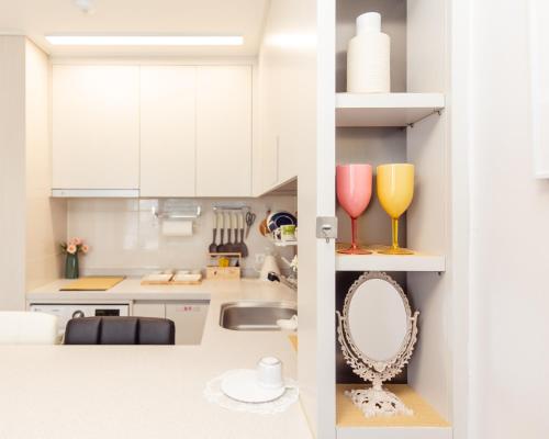 a kitchen with white cabinets and a sink and a mirror at Ocean Top Marina in Yeosu