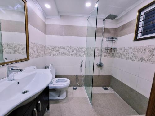 a bathroom with a toilet and a sink and a shower at Hayyat Luxury Hotel Suites in Lahore