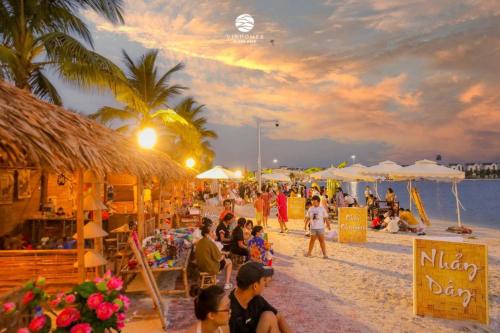 een menigte mensen op een strand bij zonsondergang bij Yody homestay Ruby Zenpark Vinhomes Ocean Park, Gia Lâm 1N plus in Hanoi