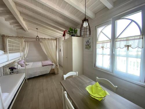 ein Zimmer mit einem Tisch und ein Schlafzimmer mit einem Bett in der Unterkunft Villa Poggio Ulivo Pool-Apartments in Rivoli Veronese