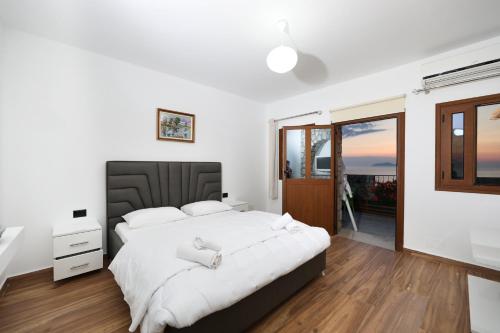 a bedroom with a large bed and a window at Vila Dena in Vlorë