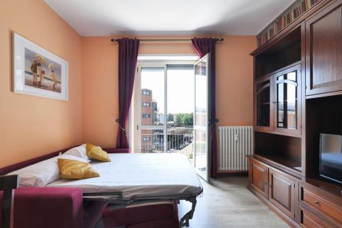 Schlafzimmer mit einem Bett, einem TV und einem Fenster in der Unterkunft Mila Apartments Brizi in Mailand