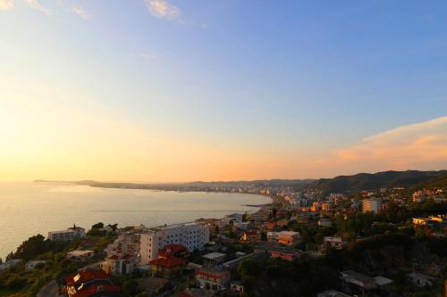 a view of a city and the ocean at sunset at Vila Dena in Vlorë