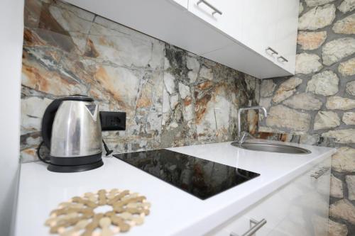 a kitchen with a sink and a coffee pot on a counter at Vila Dena in Vlorë