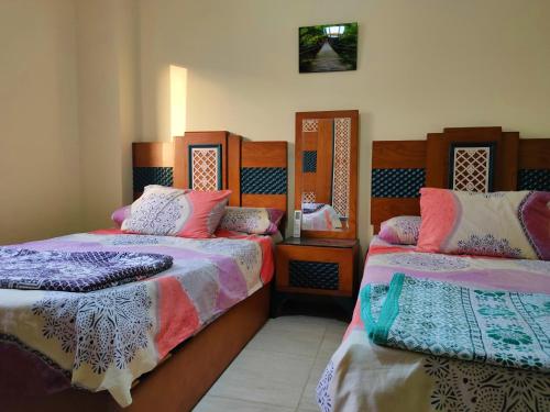 a bedroom with two beds and a mirror at قريه لاسرينا العين السخنة in Ain Sokhna