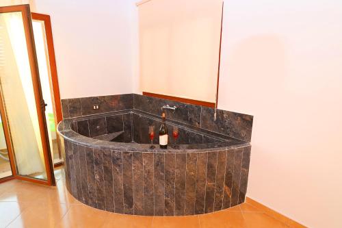 a bath tub with two bottles of wine in it at Vila Dena in Vlorë