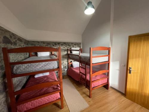a room with three bunk beds and a door at Casa Rustica da Maloeira in Malseira