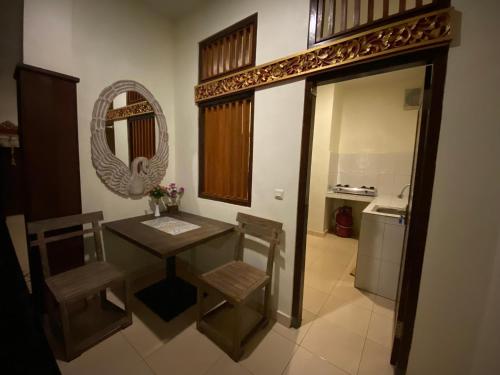 y baño con mesa, sillas y espejo. en Brata Inn Ubud en Ubud