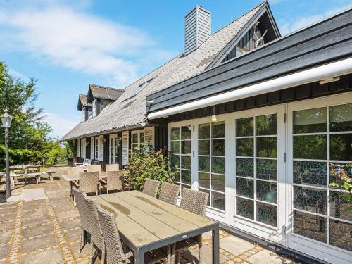 an outdoor patio with a wooden table and chairs at 19 person holiday home in L gst r in Trend