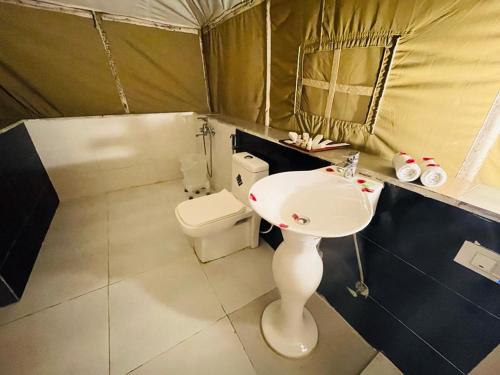 a bathroom with a sink and a toilet in a tent at Jungle Journey- A Lake Resort in Kumbhalgarh