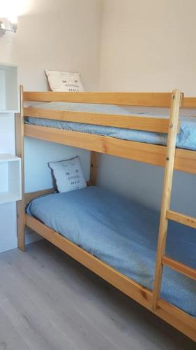 Cette chambre comprend 2 lits superposés avec des draps bleus. dans l'établissement Maison entière, Terrasse, piscine, Proche plage, à Narbonne-Plage