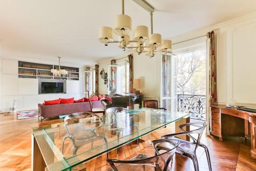 ein Wohnzimmer mit einem Glastisch und Stühlen in der Unterkunft Appartement 140m2 proche des Champs Elysées in Paris