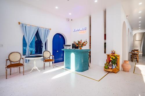 a room with chairs and a table and a blue door at Happiness Hotel in Quy Nhon