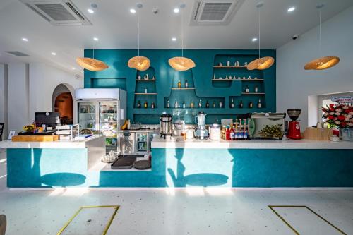 a large kitchen with blue walls and a counter at Happiness Hotel in Quy Nhon
