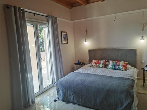 een slaapkamer met een bed en een groot raam bij Peacefull Sea View Maisonette in Petrití