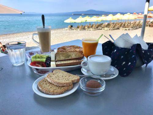 uma mesa com um prato de sanduíches e café na praia em SEMIRAMIS SUITES with pool and private jacuzzi em Kalamata