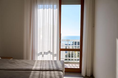 A bed or beds in a room at Appartamenti Residence Marcello-Piazza Torino-Lido di Jesolo